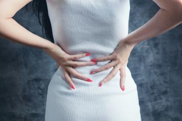 a woman holding her back in discomfort 