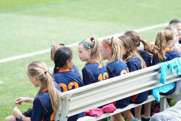 young girls sitting on a sports bench