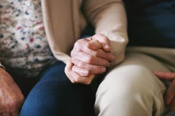 an elderly couple holding hands 