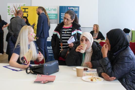 a group of women talking at a table 