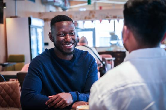two men talking and smiling